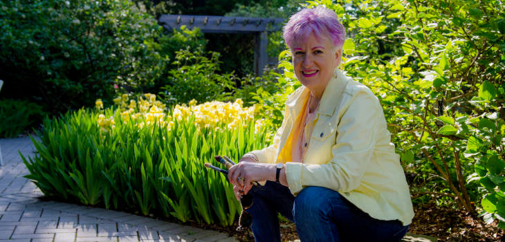 Artist Anne Nordhaus-Bike outside in garden holding paintbrushes