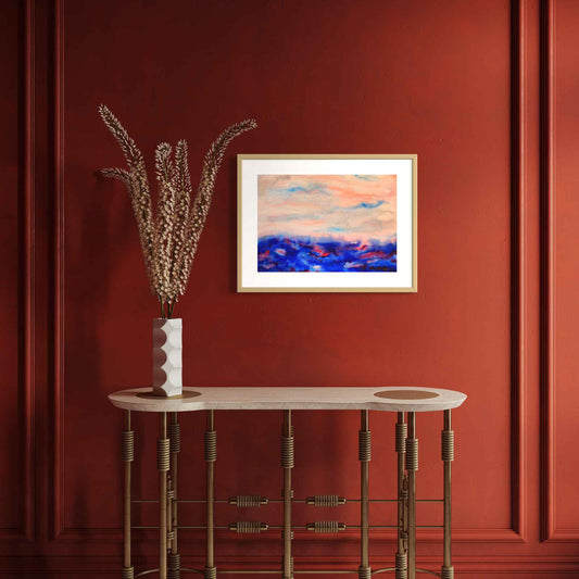 April Morning blue, pink, peach horizon watercolor on rich orange wall above side table with vase