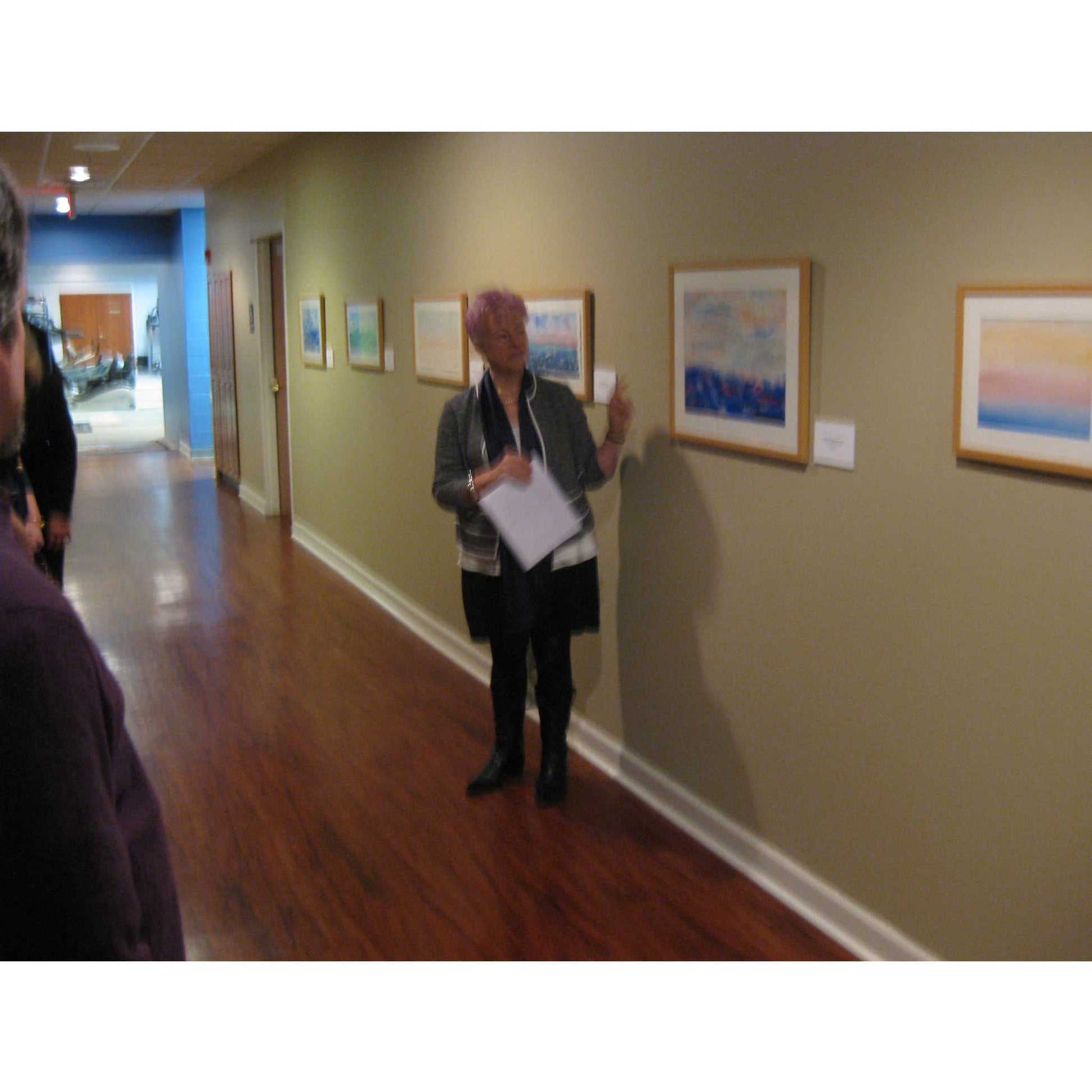 Artist Anne Nordhaus-Bike at art talk for horizons watercolor show, next to April Morning painting