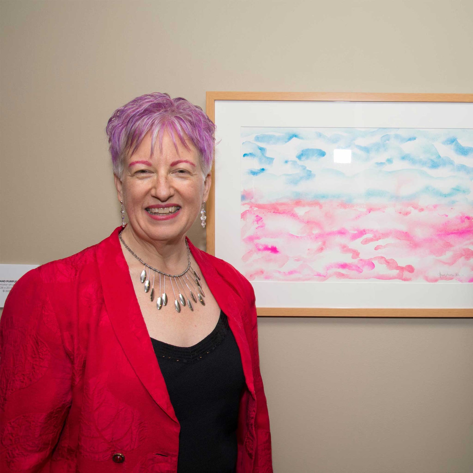 Artist Anne Nordhaus-Bike in red jacket, next to Cotton Candy watercolor