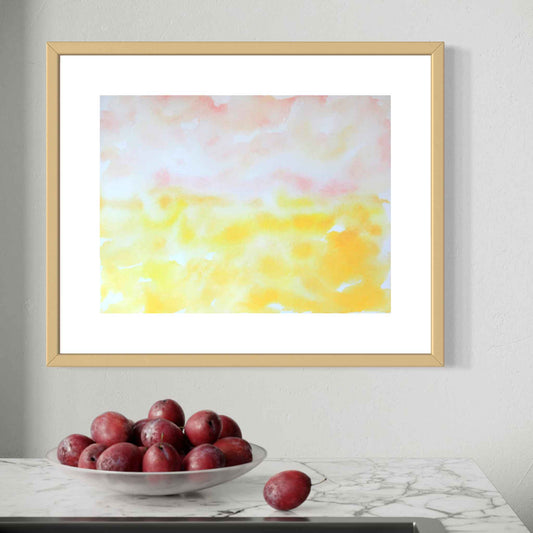 Dawn pink and yellow horizon watercolor, birchwood framed, on kitchen wall with bowl of red fruit