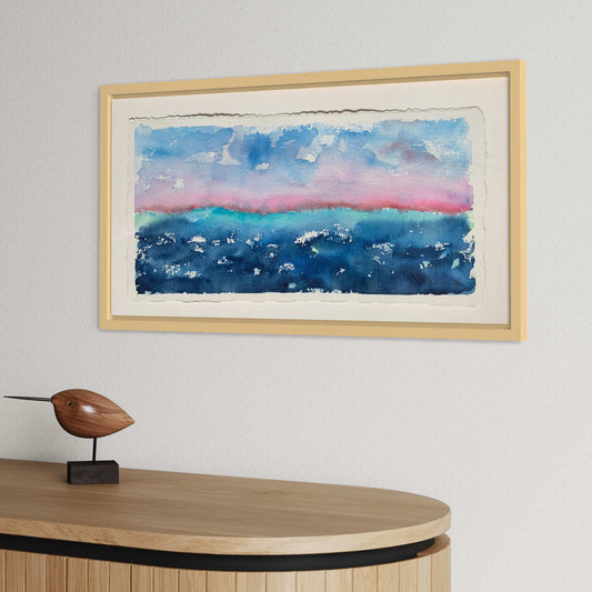 Dawning framed pink dark blue horizon landscape watercolor painting displayed above wood cabinet