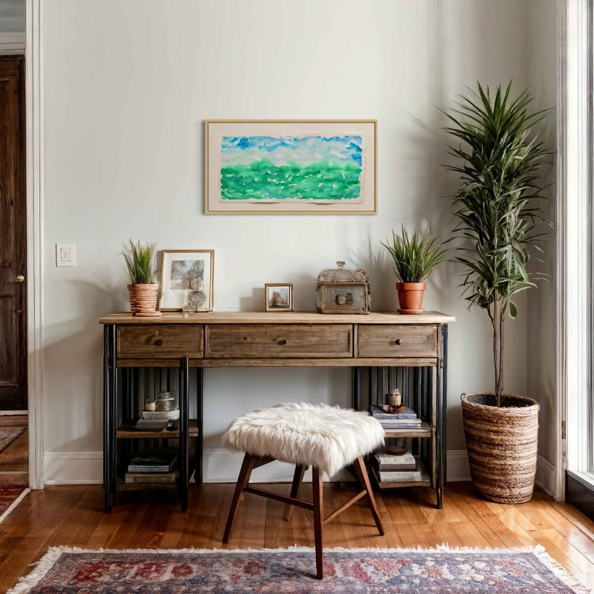Gathering Mist blue green horizon watercolor painting, above side table with photos and plants