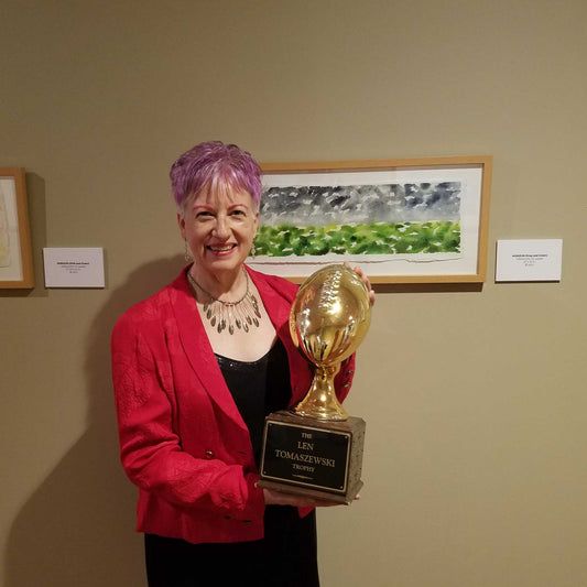 Artist Anne Nordhaus-Bike with football trophy and dramatic, stormy Rain framed watercolor painting