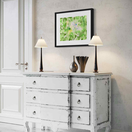 Silver blue dragonfly in green garden watercolor painting, framed, angled view in white room