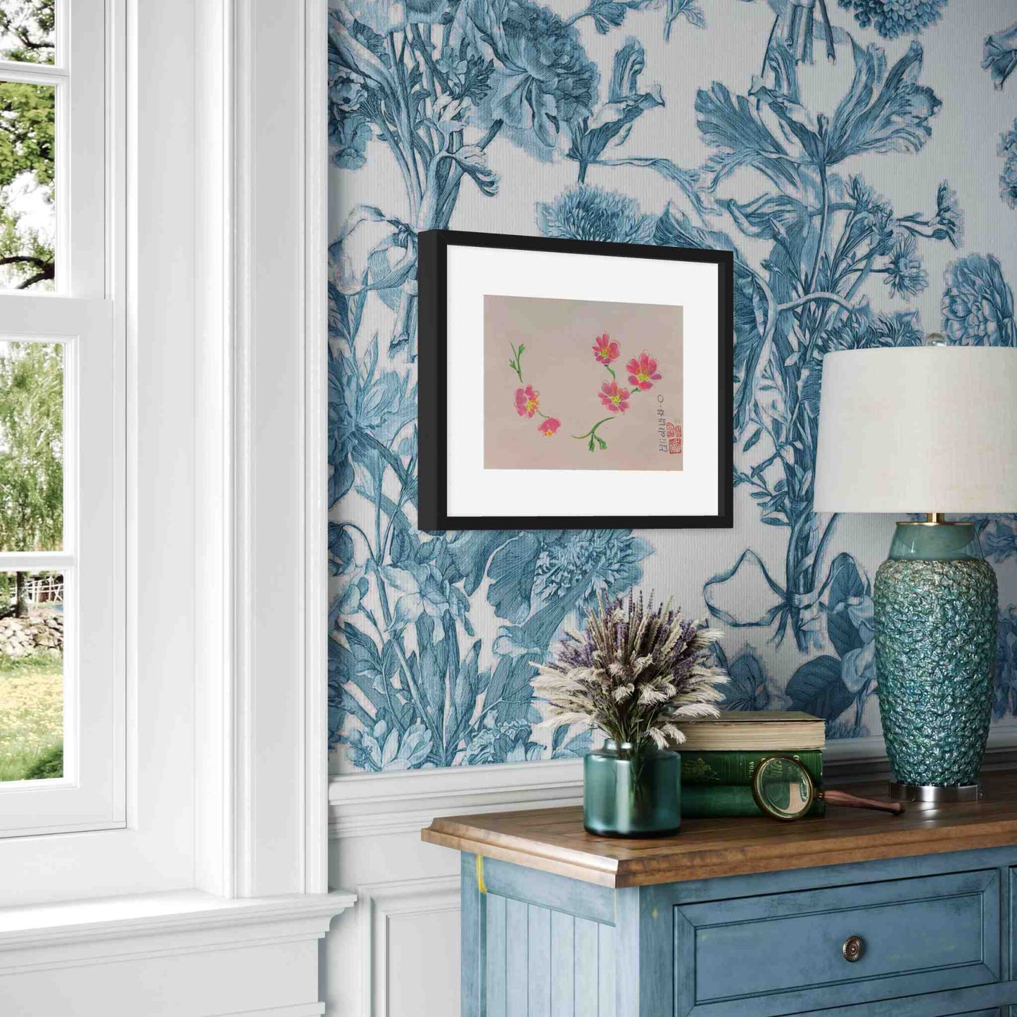 Framed watercolor bright pink flowers, angled view in room with blue and white floral wallpaper
