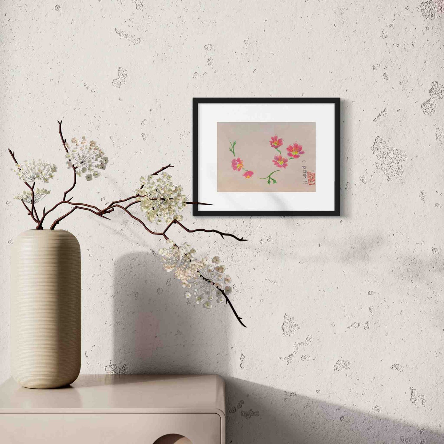 Framed watercolor showing five bright pink flowers, displayed in sunny white room