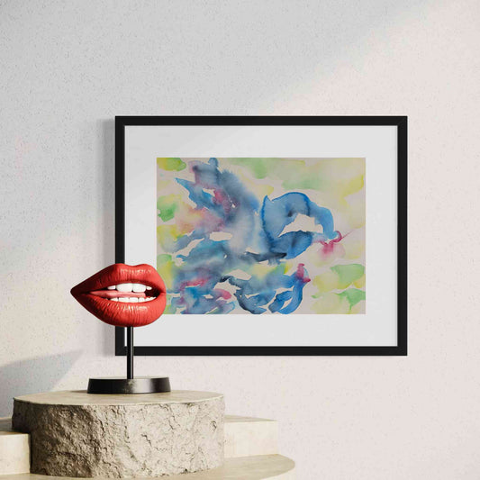 Fun, whimsical blue sea creature framed watercolor painting closeup view beside red lip sculpture