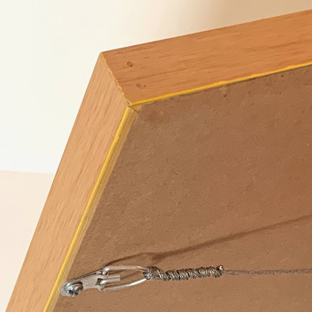 Framed watercolor, birchwood frame angled corner detail view-brown wrap, hanging wire, and hardware