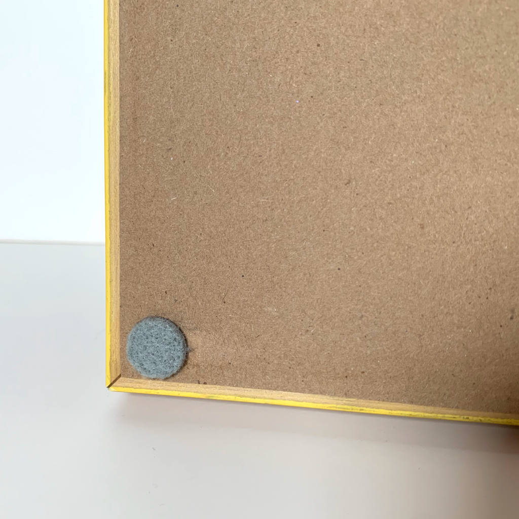 Framed watercolor painting detail view of back lower corner with felt pad