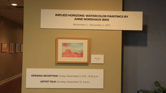 Art exhibit title, painting, and other placards at installation day