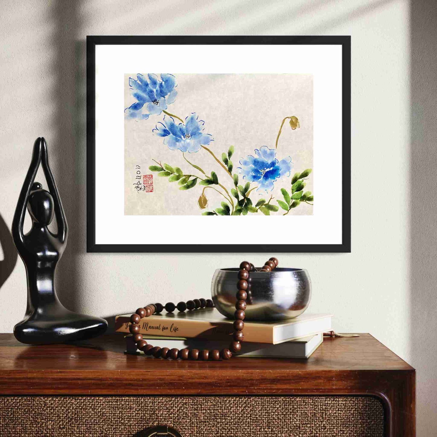 Watercolor painting of three blue flowers, closeup view above cabinet with sculpture